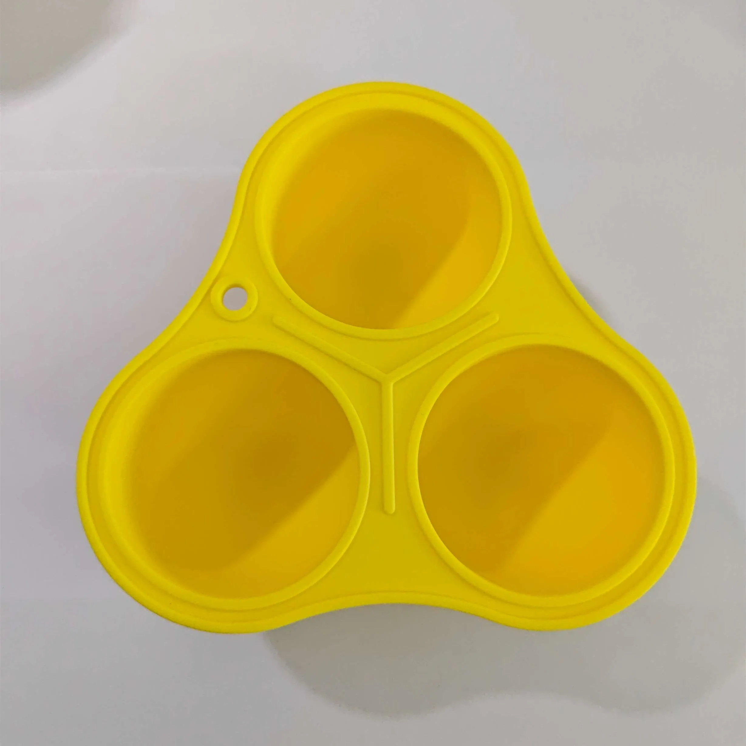 Yellow silicone pet slow feeder ball with snack mould for dogs and cats