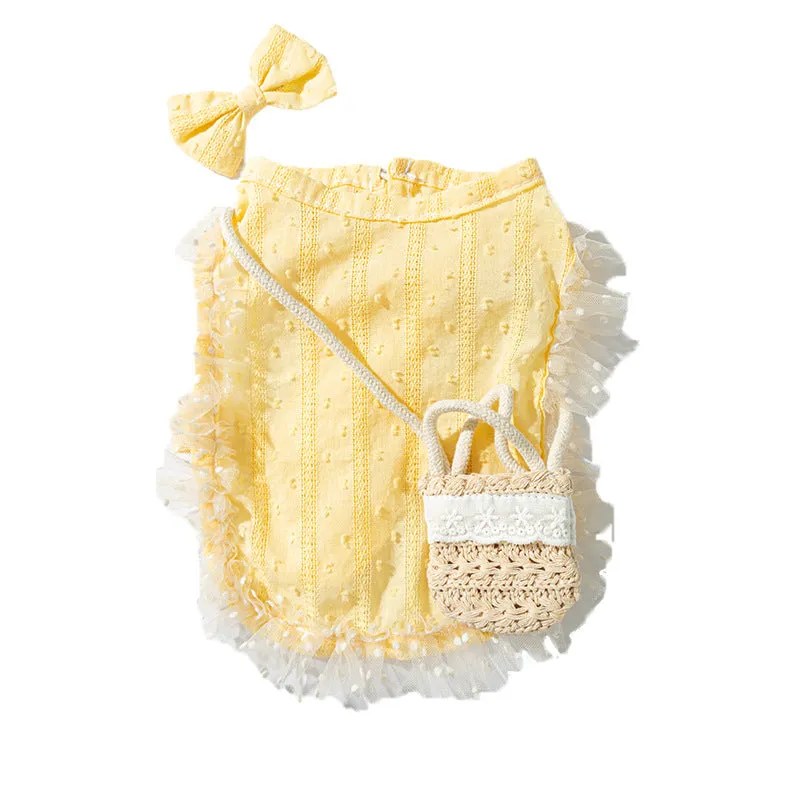 Two-tone blue sleeveless pet outfit with ruffles, matching bow, and small woven crossbody bag on a small dog