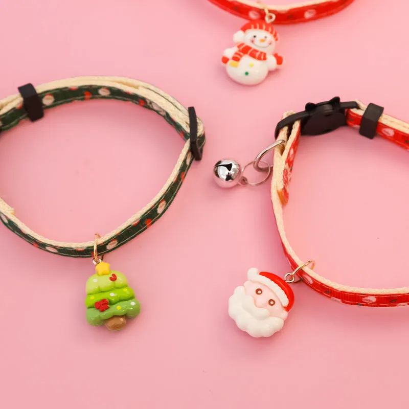Christmas pet collar with bow tie, bell, and adjustable strap featuring Santa Claus and tree patterns