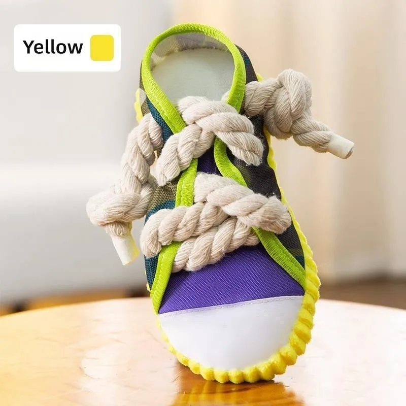 Grey and white dog toy slipper with black laces, blue sole, and a bell on the side