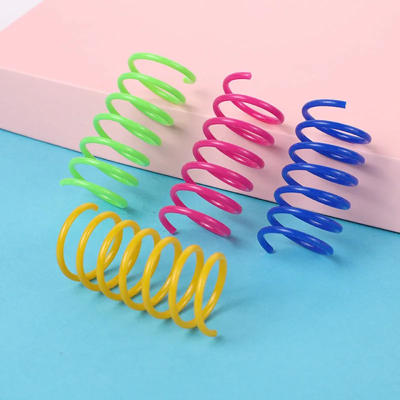 Colourful plastic coil spring cat toys shown in a mixed group, each measuring 5.5 cm long.