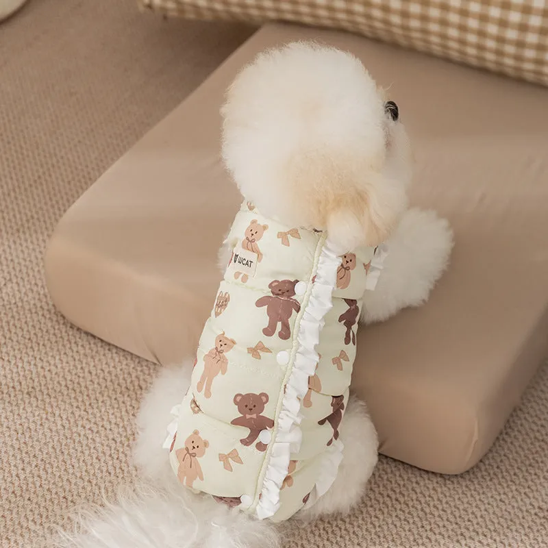 Small dog wearing cream fleece jumpsuit with bear pattern and white ruffles