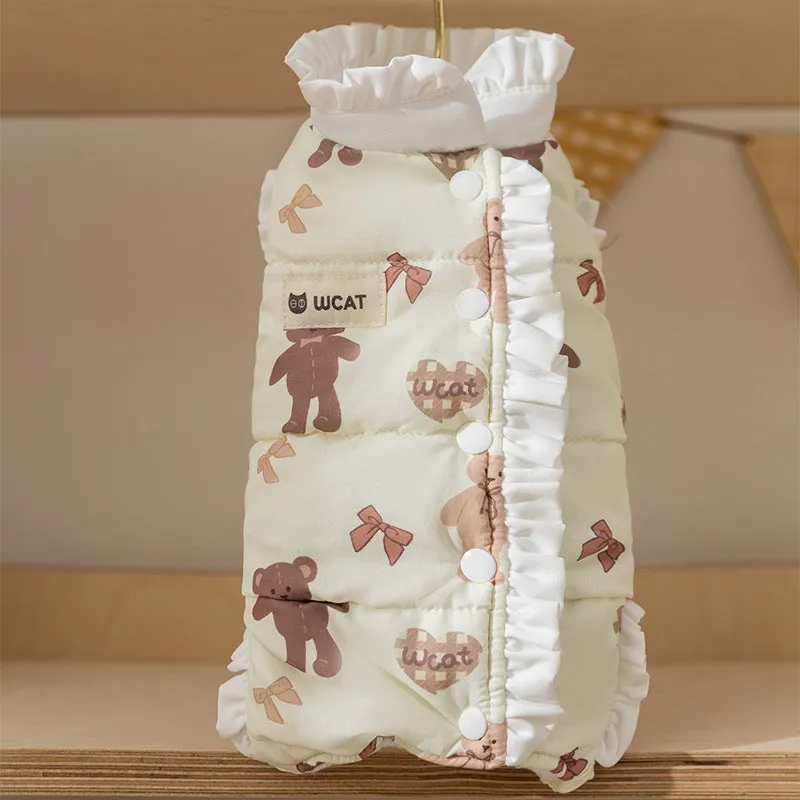 Small dog wearing cream fleece jumpsuit with bear pattern and white ruffles