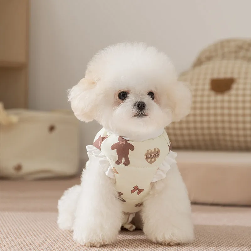 Small dog wearing cream fleece jumpsuit with bear pattern and white ruffles