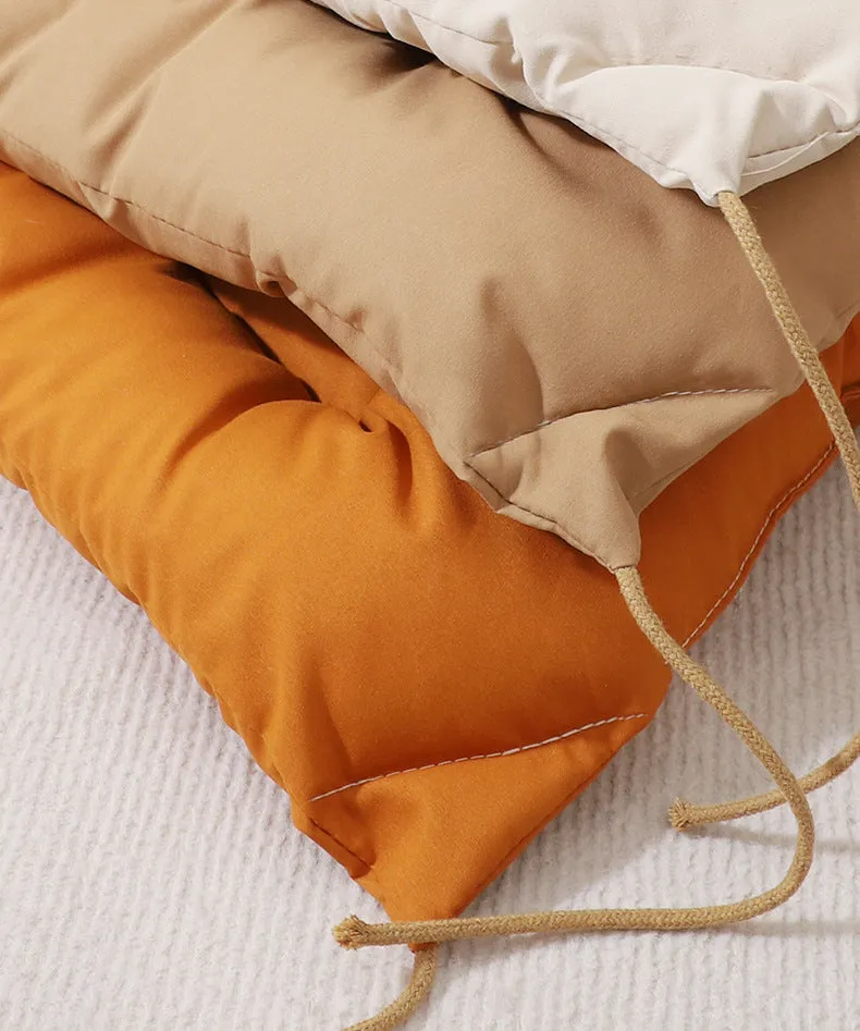 Beige tied cage cushion for small dog in crate showing secure attachment and warm bedding platform.
