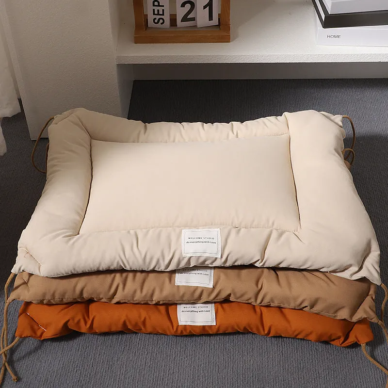 Beige tied cage cushion for small dog in crate showing secure attachment and warm bedding platform.