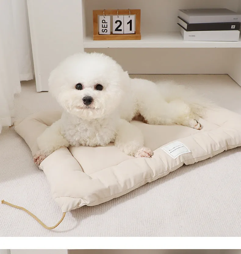 Beige tied cage cushion for small dog in crate showing secure attachment and warm bedding platform.