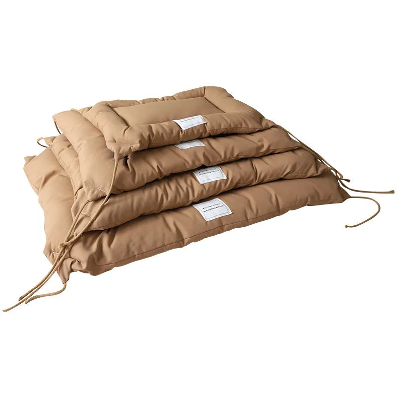 Beige tied cage cushion for small dog in crate showing secure attachment and warm bedding platform.