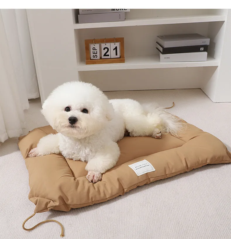 Beige tied cage cushion for small dog in crate showing secure attachment and warm bedding platform.
