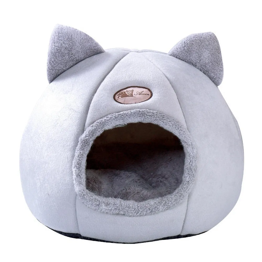 A large fully enclosed sofa-shaped cat winter house with a removable fleece cushion inside, shown in a home setting.