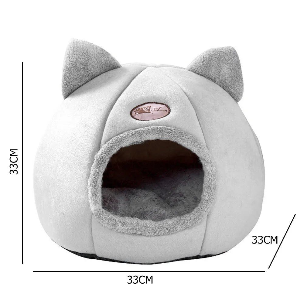 A large fully enclosed sofa-shaped cat winter house with a removable fleece cushion inside, shown in a home setting.