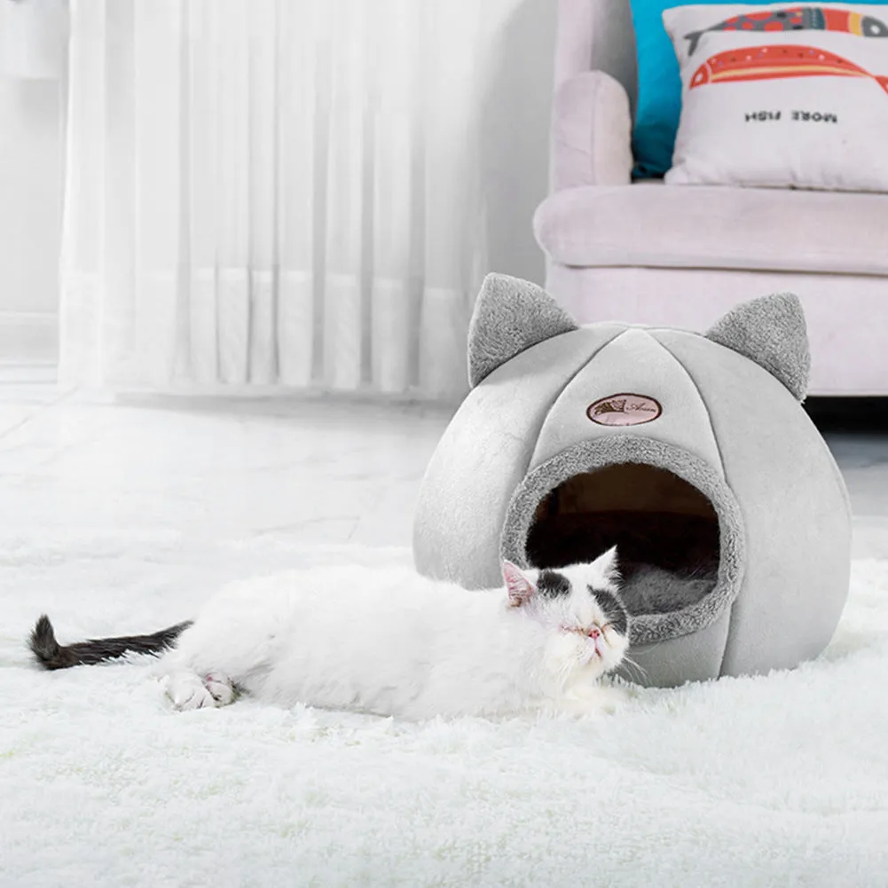 A large fully enclosed sofa-shaped cat winter house with a removable fleece cushion inside, shown in a home setting.
