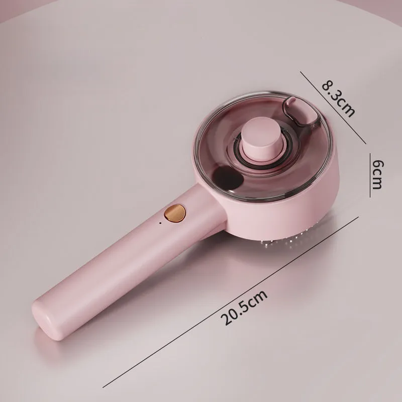 Pink and white cat grooming steam brush with mist function, rounded head, and stainless steel bristles.