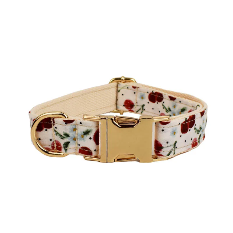 Red cherry print cloth dog collar with light gold release buckle, part of a five-piece pet accessory set.