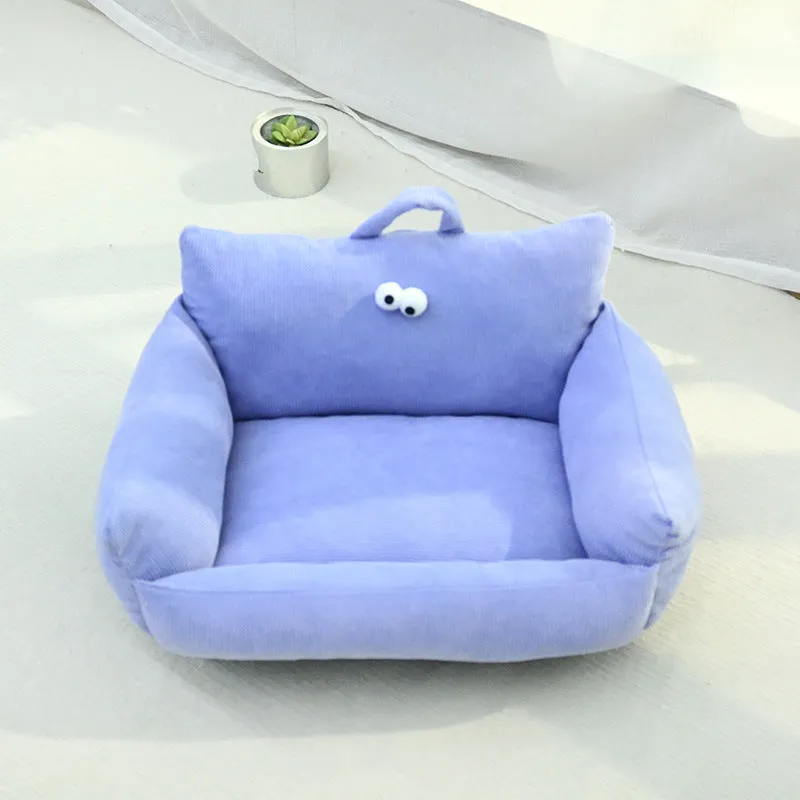 Blue cartoon big eye pet sofa kennel bed for small dog on a wooden floor.