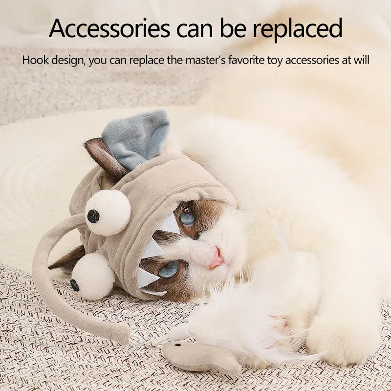 Grey head-mounted cat toy with feather and big-eye fish attachments on adjustable elastic band
