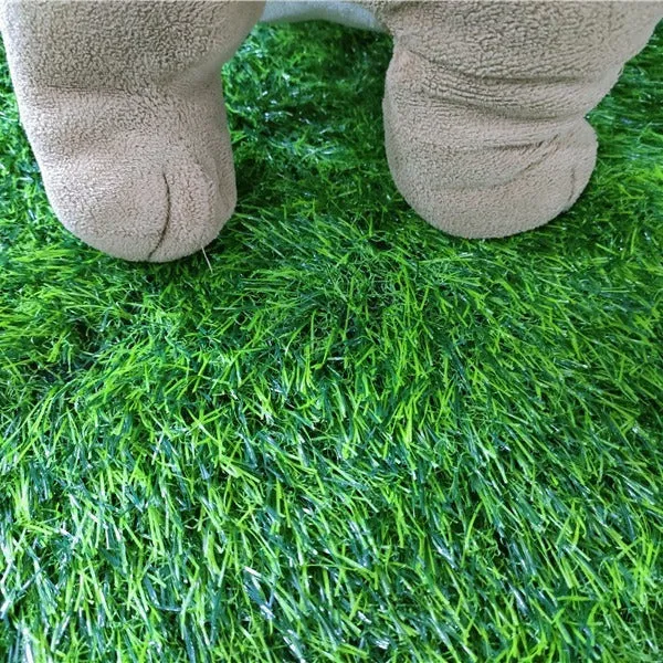 Green washable dog grass pee pad with realistic lawn texture on a patio.