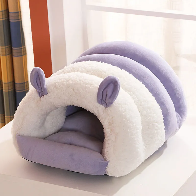 Blue enclosed cat bed with removable fleece liner, shown in a home setting.