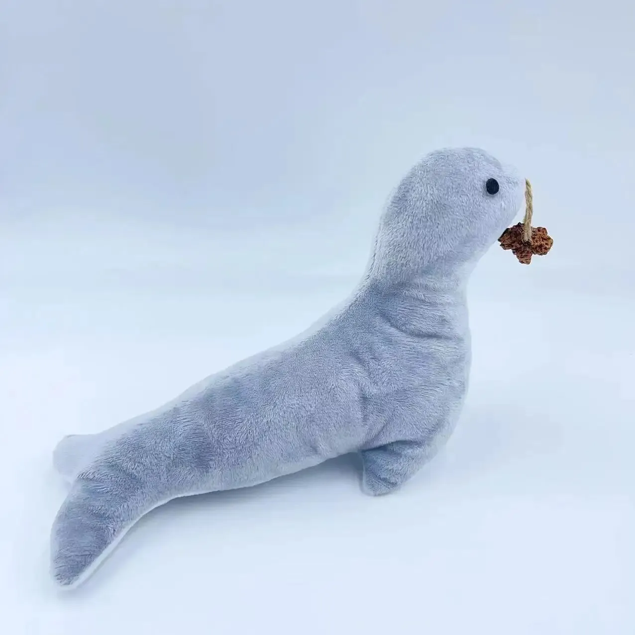 Blue sea lion plush cat toy with embroidered details on a white background.