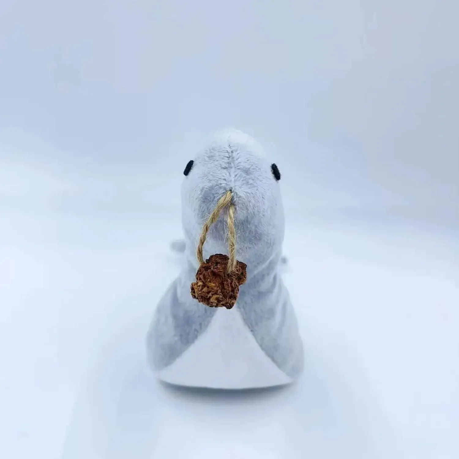 Blue sea lion plush cat toy with embroidered details on a white background.