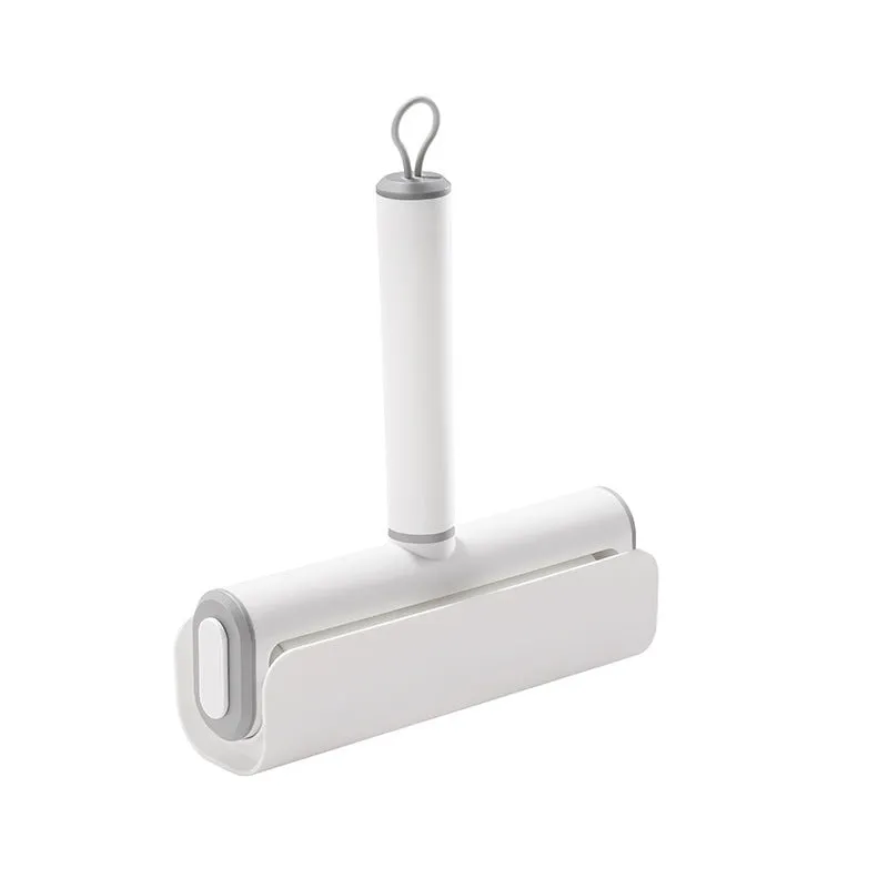 Handheld lint remover roller for pet hair removal on floors with tearable paper stick.