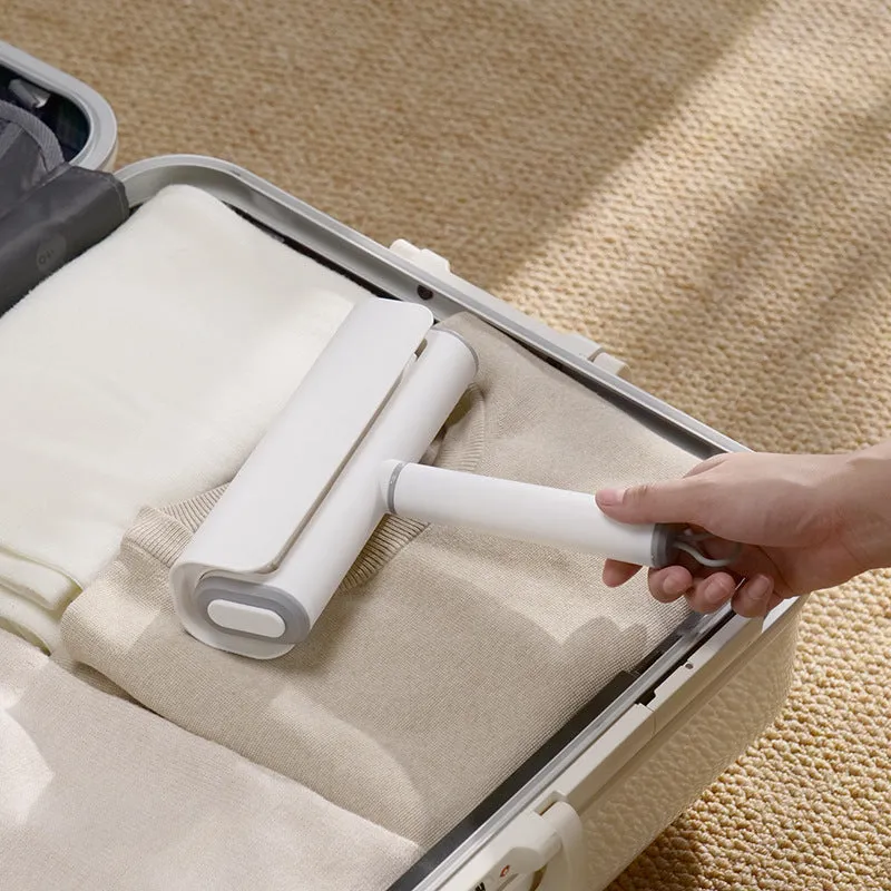 Handheld lint remover roller for pet hair removal on floors with tearable paper stick.