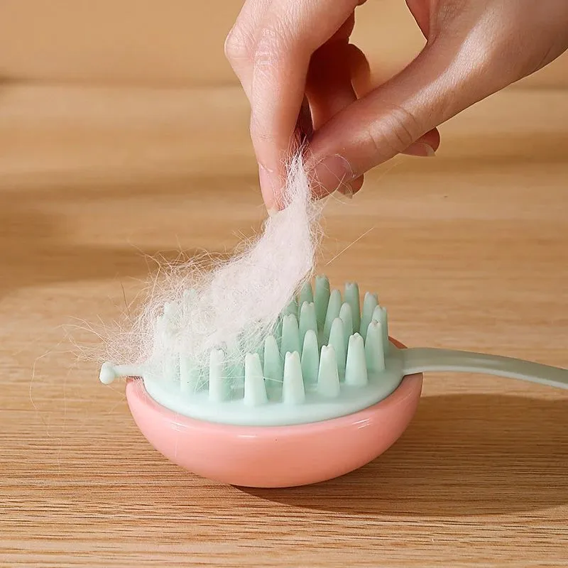 Blue silicone pet bathing and grooming brush with soft bristles and an ergonomic handle.