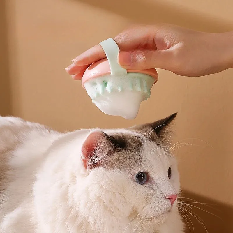 Blue silicone pet bathing and grooming brush with soft bristles and an ergonomic handle.