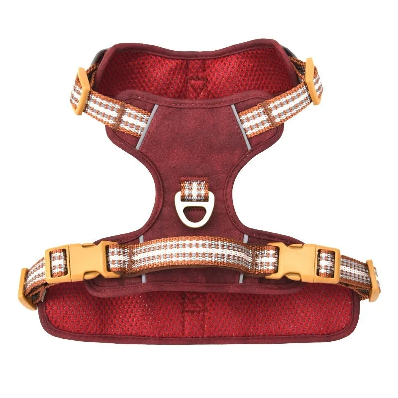 Brown leather dog harness with reflective strips and D-ring attachment on wooden background
