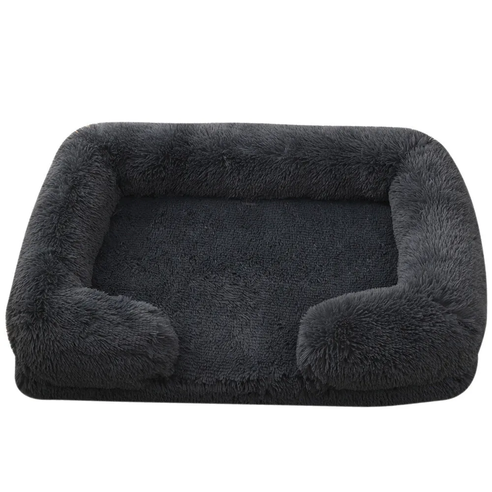 Plush round dog bed in beige brown with raised edges and a removable inner sleeve.