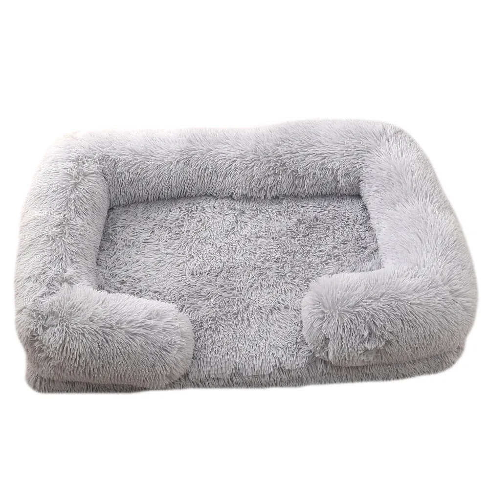 Plush round dog bed in beige brown with raised edges and a removable inner sleeve.