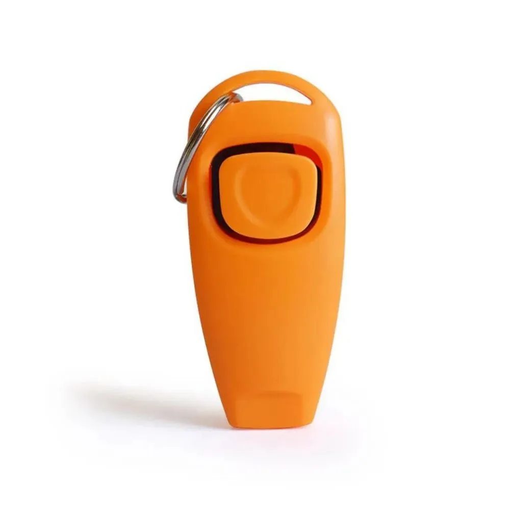 Pet training clicker and whistle set with key ring in orange, white, and blue plastic on a wooden table