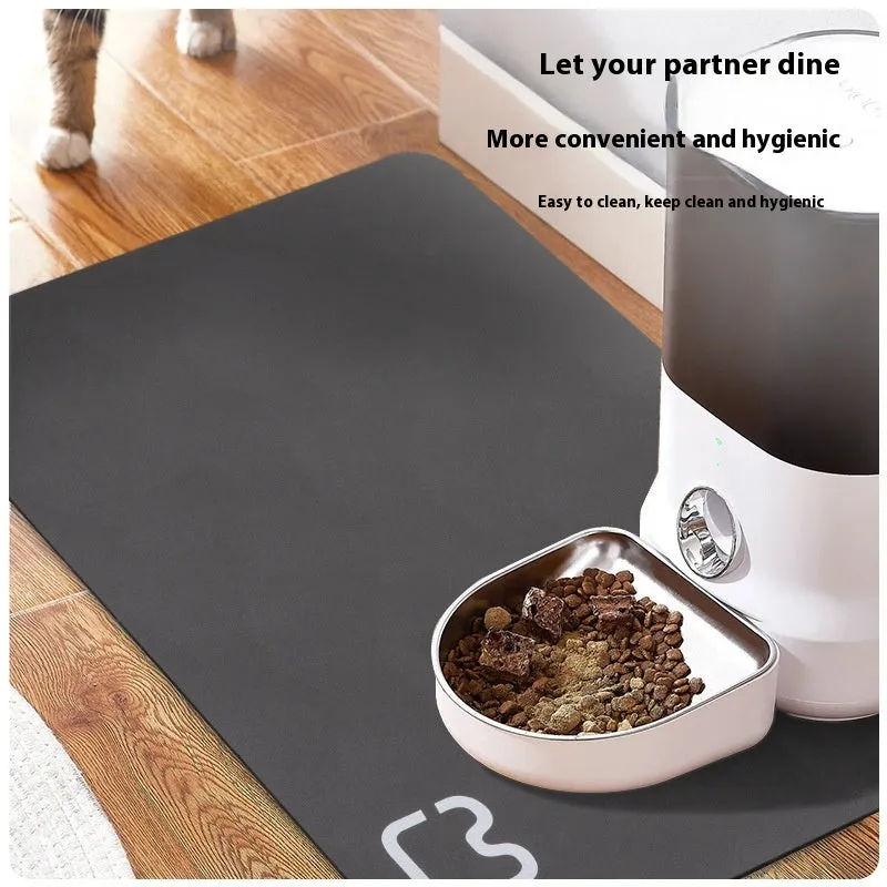 Pet feeding mat with non-slip backing in a dog paw print design on a hardwood floor.