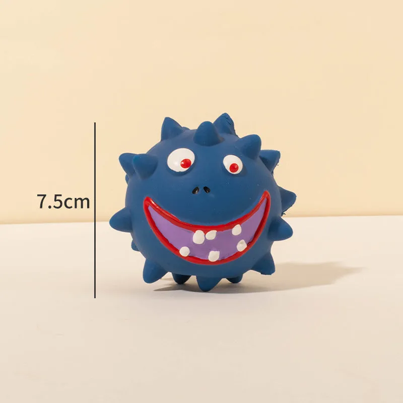 Set of four colourful latex squeaky dog balls with cute faces on a textured surface.