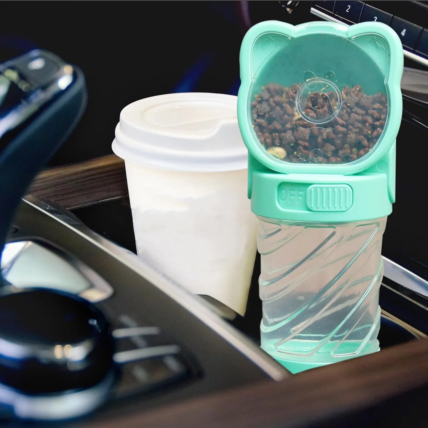 Green 3-in-1 portable pet water bottle with food container and bag dispenser, held by its strap.
