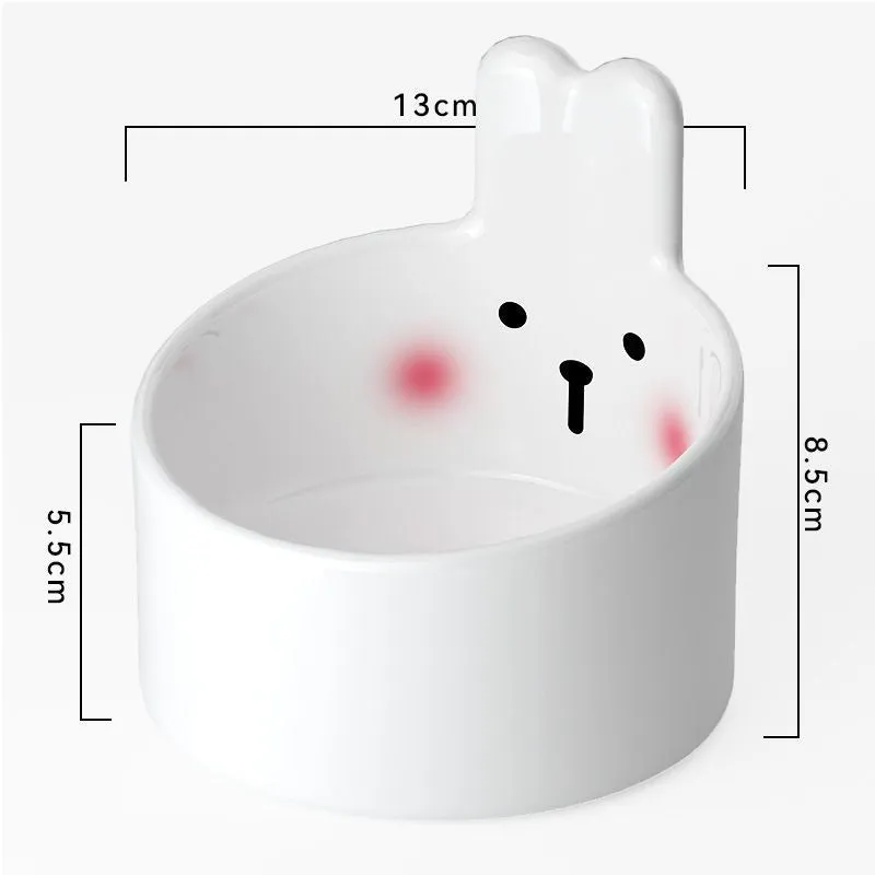 White ceramic pet food bowl with slant design on a plain surface