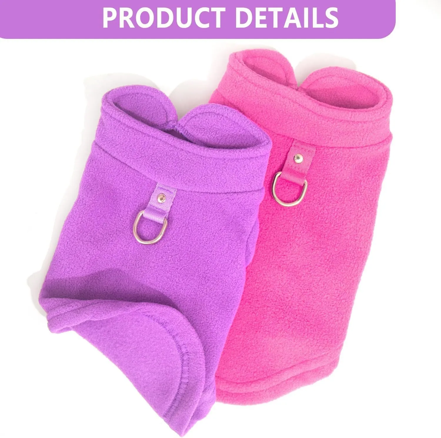 Two small dogs wearing fleece sweaters with built-in D-ring for leash, one in blue green and one in purple pink