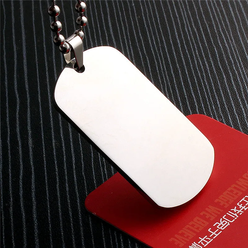 Stainless steel dog tag pendant with polished finish, 50x29mm, and silencing ring attached