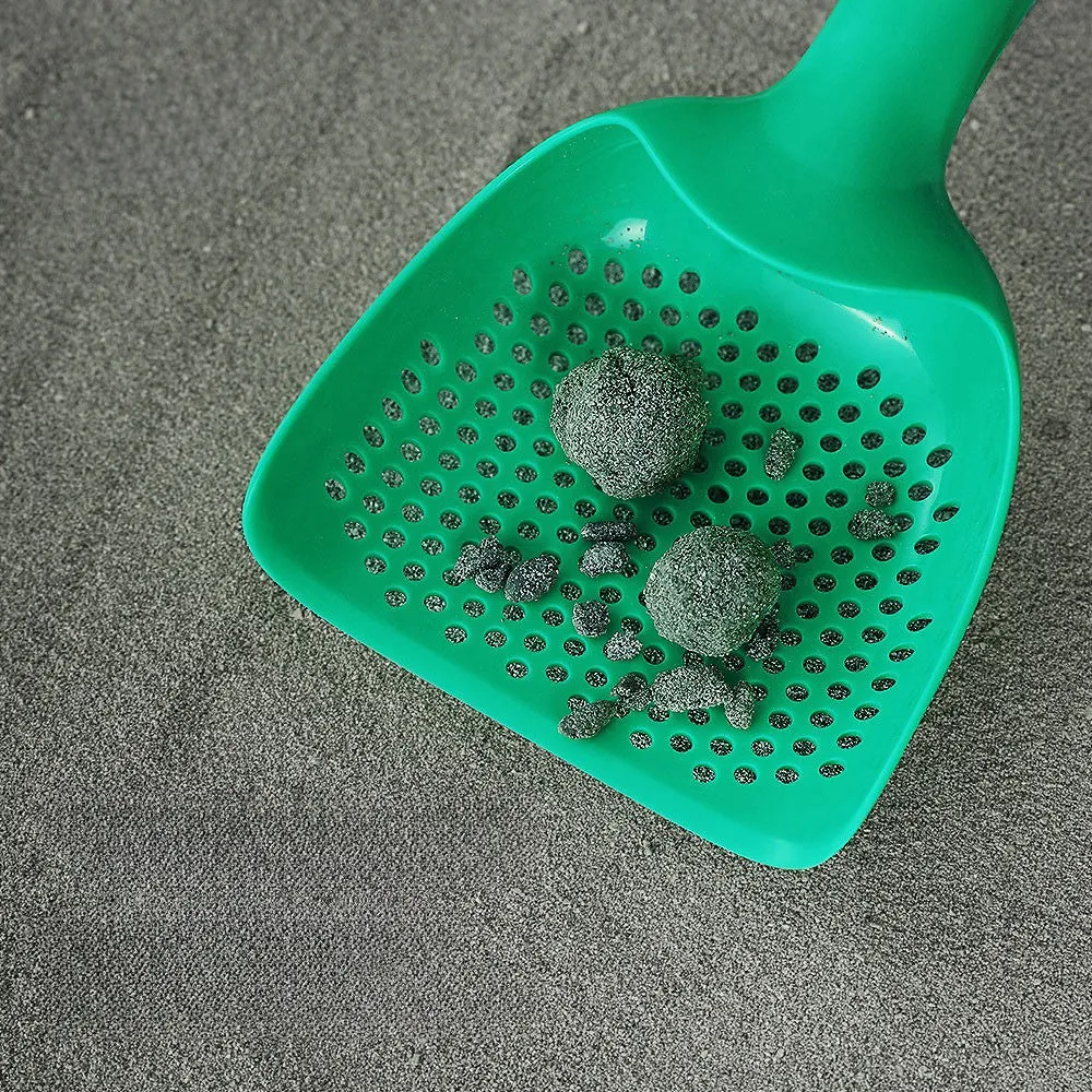 Green plastic cat litter scoop with hollow head and handle on white background