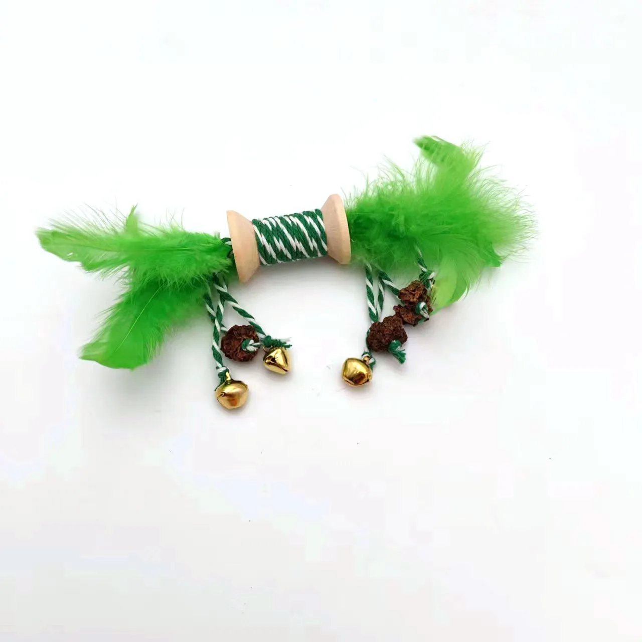 Feather bell gall fruit cat toy in ginger colour with bells and feathers on green background