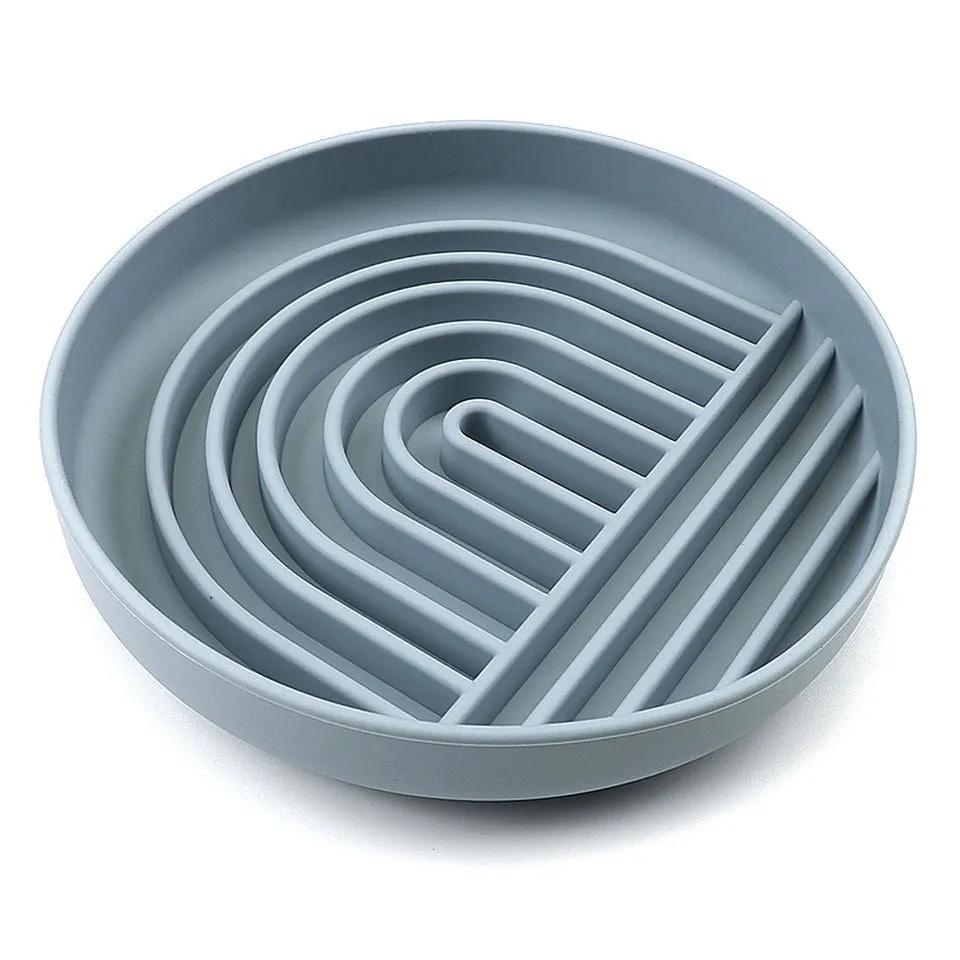 Silicone slow feeder dog bowl with ridges in various colours on a table.