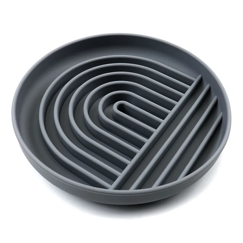 Silicone slow feeder dog bowl with ridges in various colours on a table.