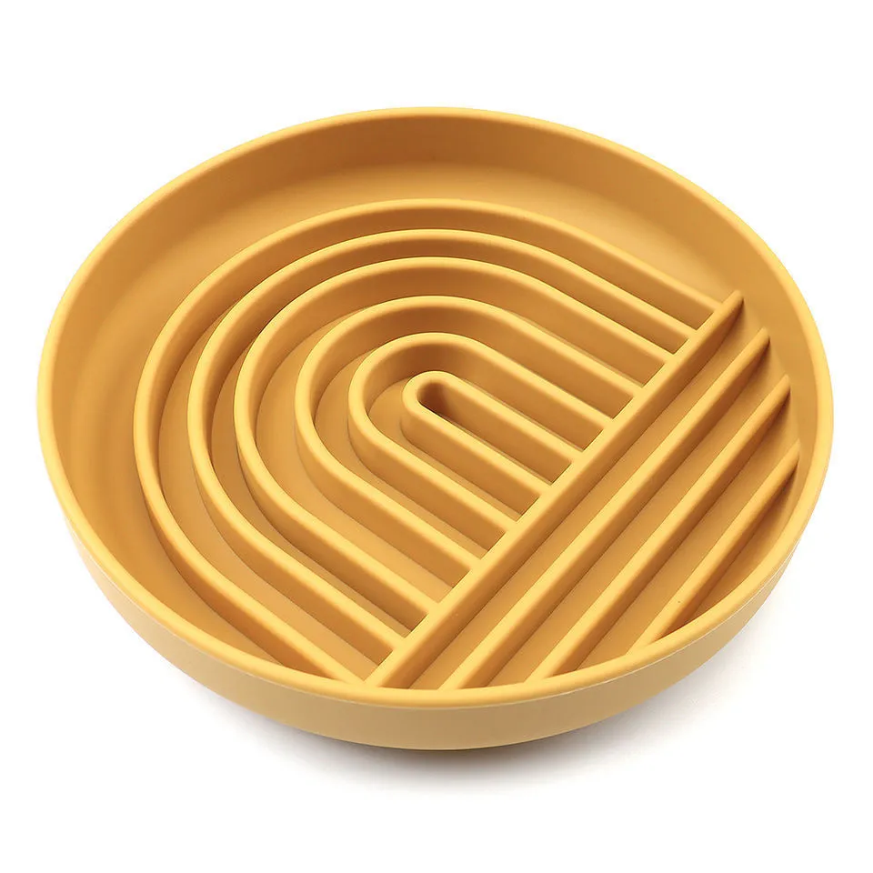 Silicone slow feeder dog bowl with ridges in various colours on a table.