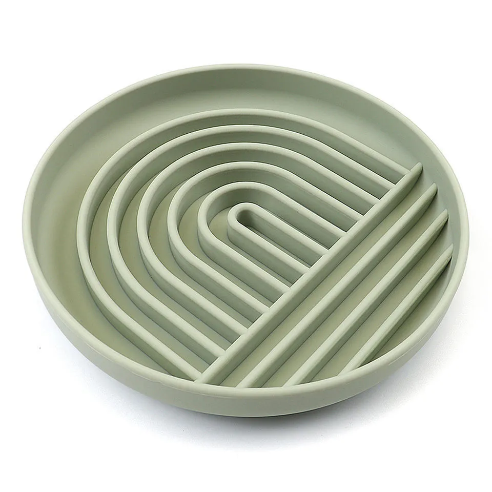 Silicone slow feeder dog bowl with ridges in various colours on a table.