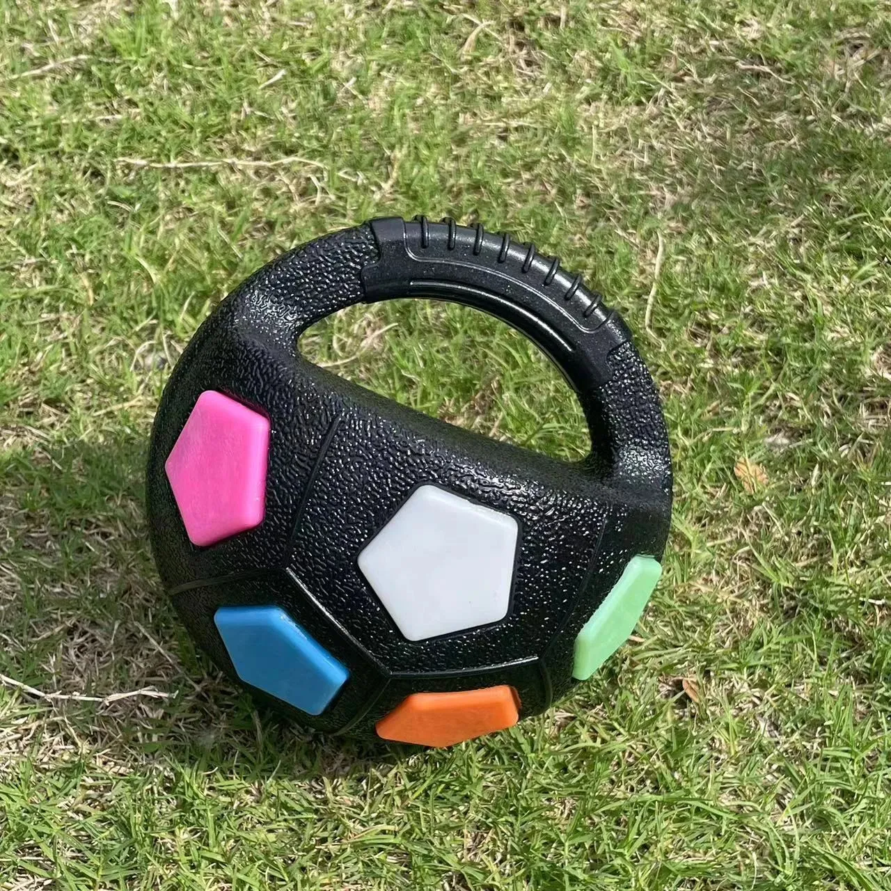 Football tennis ball shaped dog toy in black with squeaker for fetch and teething relief