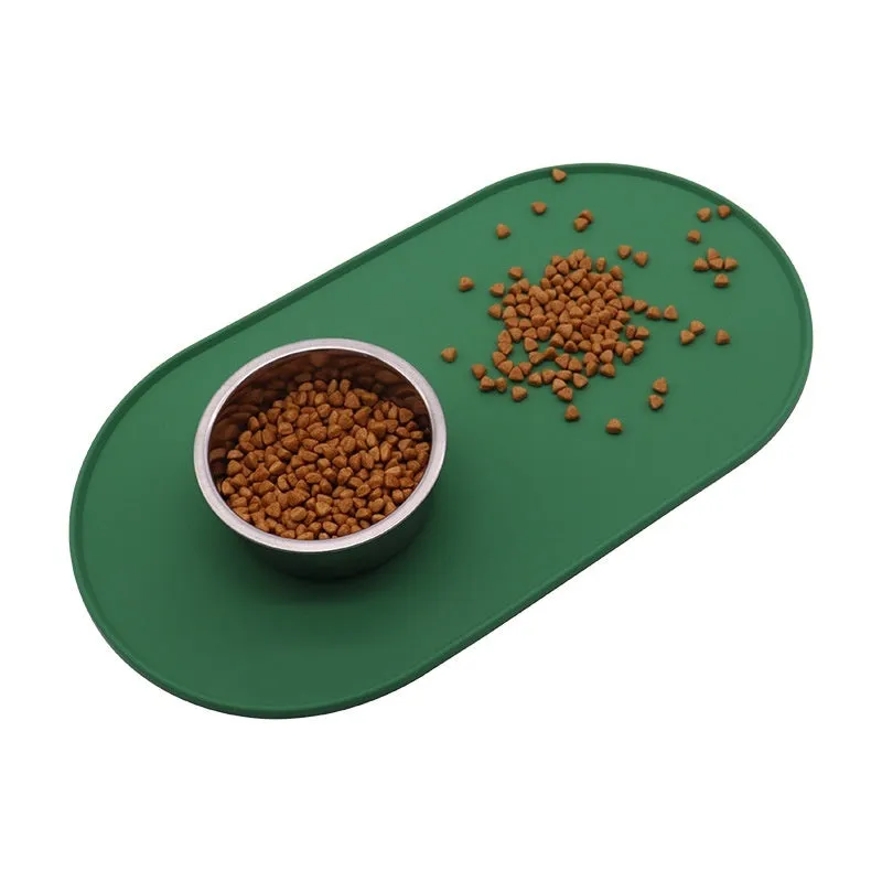 Silicone waterproof cat feeding placemat in beige colour on a floor next to a food bowl.