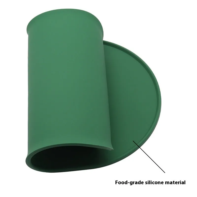 Silicone waterproof cat feeding placemat in beige colour on a floor next to a food bowl.