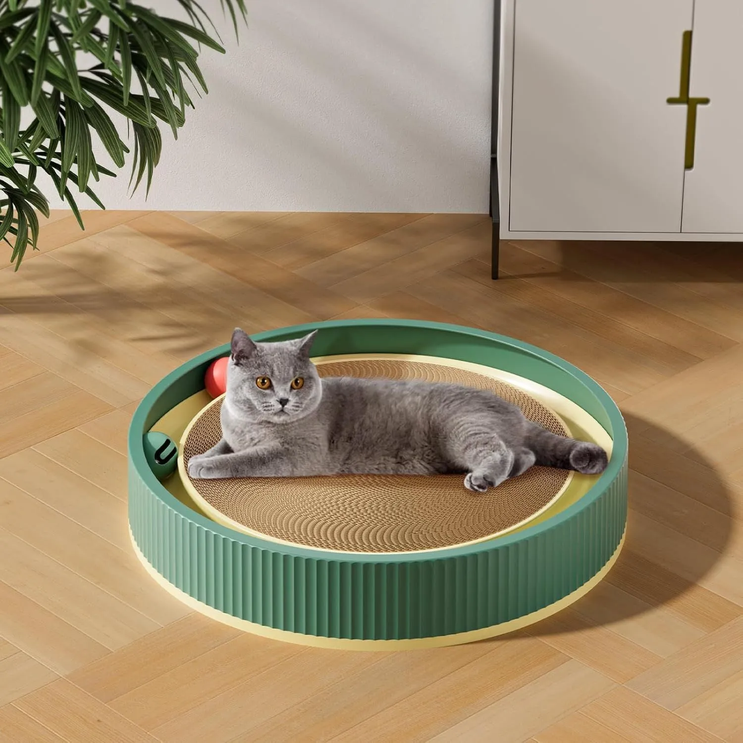 Large green circular cardboard cat scratching board with three built-in ball toys on a white base.
