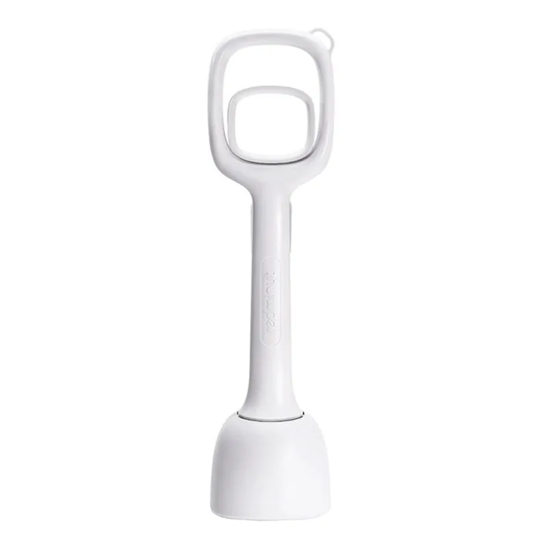 White plastic pooper scooper with clip shovel design for dog waste pick-up on grass