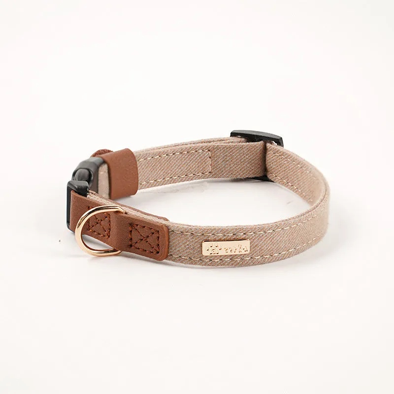Adjustable mohair dog collar with nameplate and hand holding rope in cement gray